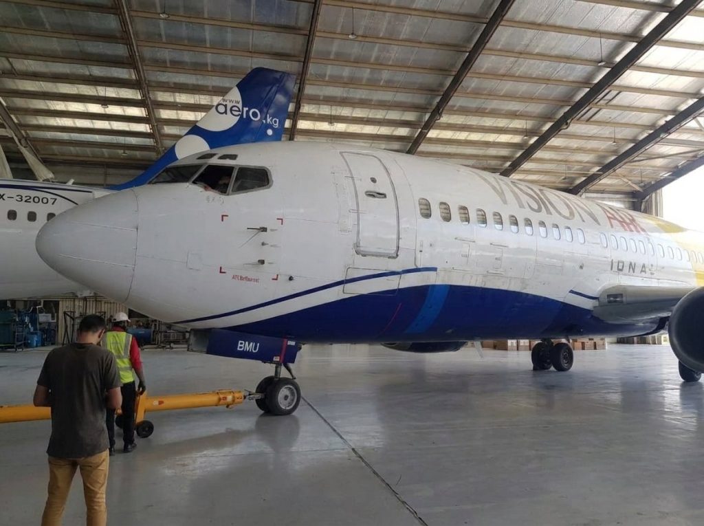A Boeing 737 being towed into the hangar by the ground crew